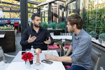 Wall Mural - Two male friends talking in the cafe bar