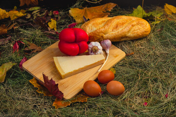 Wall Mural - still life with vegetables and cheese on a cutting board in the hay