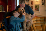 Fototapeta Londyn - Father and disabled son cuddling dog