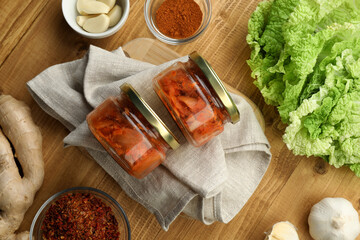 Delicious kimchi with Chinese cabbage and ingredients on wooden table, flat lay