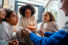 Woman Serving Birthday Cake To Female Partner At Home