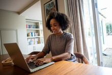 Smiling Woman Using Laptop At Home