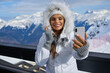 © ZoomTeam - technology and leisure concept - happy woman in winter fur hat taking selfie by smartphone outdoors