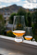 © barmalini - Glass of single malt scotch whisky served on old window sill in Scottisch house with view on old part of Edinburgh, Scotland, UK