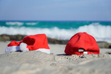 Santa Hat And A Red Visor On The Beach Of A Spanish Island. Relax On Christmas Holidays