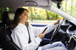 © F8  \ Suport Ukraine - Beautiful young businesswoman sending a text while driving to work