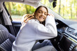 Portrait of a beautiful teenage girl smiling while holding the steering wheel.