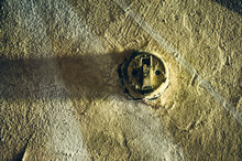 An Old Light Switch Hangs On An Old Shabby Wall, The Concrete Wall Was Painted, On The Switch Itself The Paint Has Faded In Places Due To Many Years Of Operation