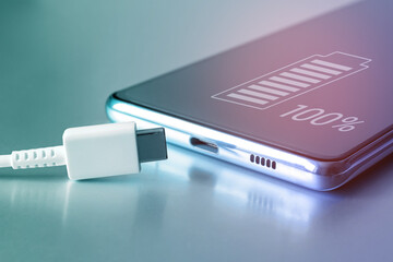 fully charged battery icon on the touch screen of the cell phone and a usb type-c cable. fully charg