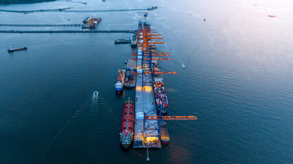 Cargo container Ship load container box to Cargo Ship at Shipyard Bridge of Container Sea port at sunset. ship under the crane Sea Port service logistics and transportation.