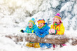 © famveldman - Kids playing in snow. Children play outdoors in winter snowfall.