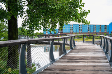 Wall Mural - Parkview Tree Canopy Trail curving wood bridge riverfront walkways in Promenade Park over the St. Marys River, Fort Wayne, Allen County, Indiana