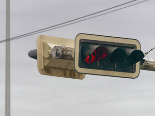 Close-up photo of a red traffic light on a metal pole with a misty sky in the background