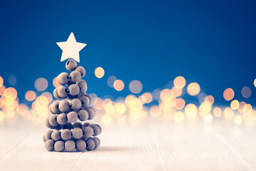 Wall Mural - Christmas tree on white table with bokeh lights.