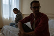© DimaBerlin - Unhappy family man and woman angry at each other for reasons of misunderstanding or financial problems. Soft focus of young guy and lady sits on opposite sides bed and hesitating to start conversation
