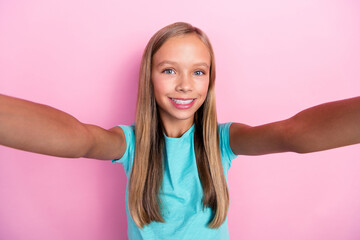 Sticker - Photo of cheerful positive small kid wear turquoise t-shirt dark tacking selfie smiling isolated pink color background