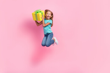 Wall Mural - Full length photo of amazed shocked small kid wear turquoise t-shirt jumping high rising present empty space isolated pink color background