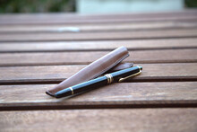Pen with leather case on a wooden table
