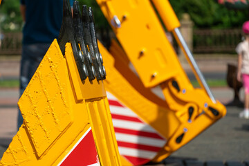 A large yellow construction excavator on a construction site. A new quarry bulldozer for the development of quarries at the exhibition of modern construction equipment. Excavator bucket close-up.