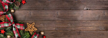 Christmas Corner Border Of Ornaments, Branches And Red And Green Plaid Bows And Ribbon. Top Down View On A Rustic Wood Banner Background.
