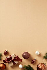 Wall Mural - Christmas vertical banner. Christmas gift box with brown ribbon bow and decorations on pastel beige background