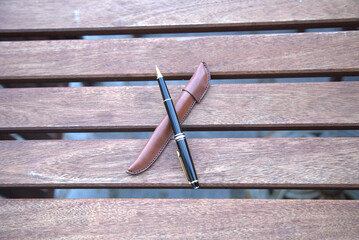 Pen with leather case on a wooden table