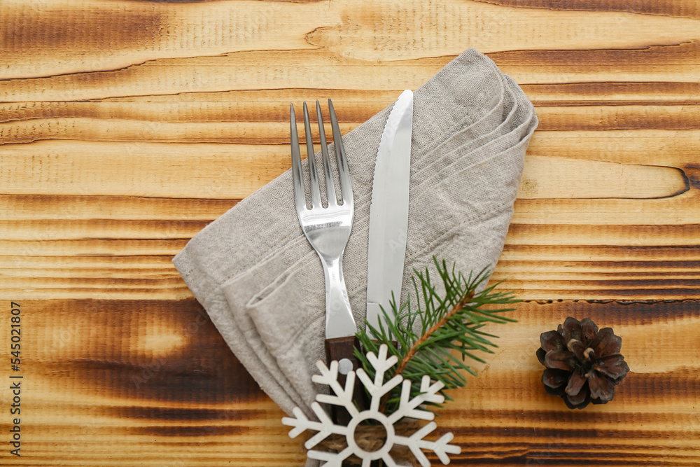 Stylish table setting for Christmas celebration and pine cone on wooden background, closeup
