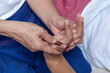 © ND STOCK - An elderly Asian woman receives a pain-relieving massage by a herbal therapist in a traditional Thai position.