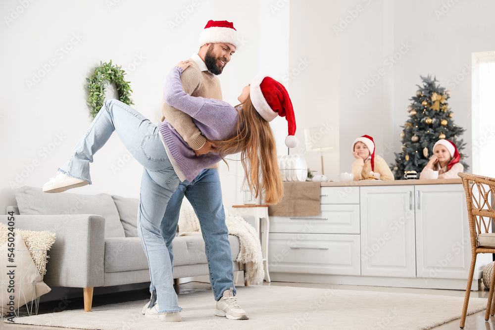 Happy parents dancing in kitchen on Christmas eve