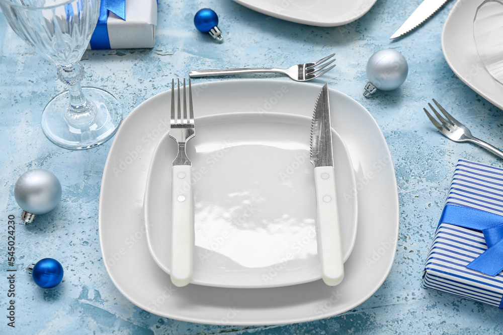 Beautiful table setting with Christmas balls and gifts on grunge background