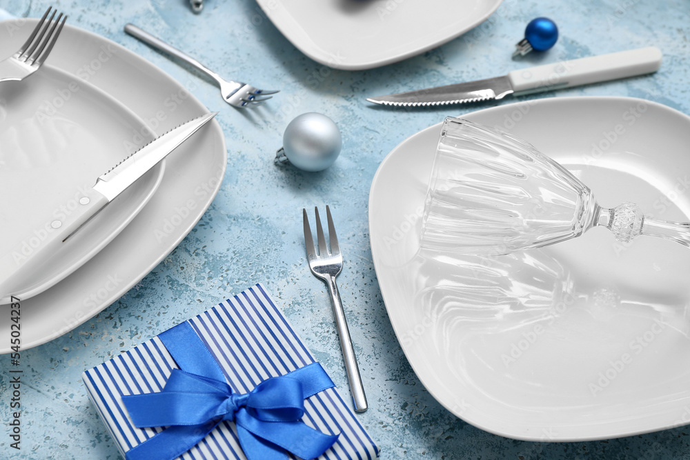 Beautiful table setting with Christmas balls and gift on grunge background, closeup