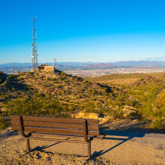 Wall Mural - Tranquil sunset mountain landscape with brown bench and communication towers at South Mountain and Preserve Public Park in Phoenix, Arizona 