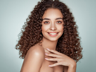 Fashion studio portrait of beautiful smiling woman with afro curls hairstyle. Fashion and beauty