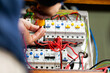© Austockphoto - Electrician tradesman rewiring switch board for solar power