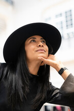 Young Woman In Black Hat Looking Up