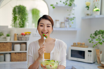 Wall Mural - Beautiful young girl with a plate of fresh vitamin salad from vegetables