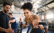 © N F/peopleimages.com - Gym, fitness and woman on bike with personal trainer for motivation, support and power workout, cheering and clapping hands. Coach, black woman and cycling exercise at sport center, sweat and energy
