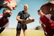 © L Ismail/peopleimages.com - Coach, soccer and team strategy on field for athlete children excited for training game together. Planning, teamwork and football coaching professional on sports ground happy with communication.