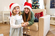 © Dragana Gordic - A mother and her daughter are at home, they are enjoying in Christmas holidays. Christmas Family and Xmas Tree, Happy Mother and Baby Child. Happy daughter embracing her mother on New Year's day.