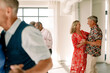 © Maskot - Smiling senior men and woman dancing together in class