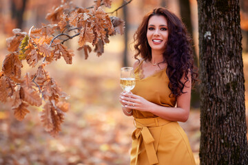 beautiful woman with long hair with a glass of wine in her hand autumn