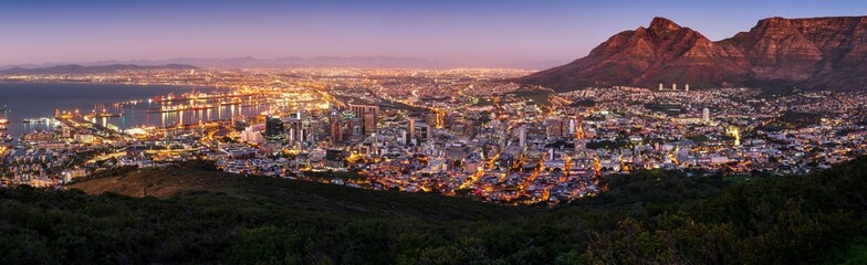 Wall Mural - Panoramic shot of Cape Town with city lights at sunset