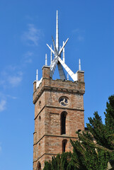 Wall Mural - Scottish Stone Church Church Tower with Decorative Saltire seen between against Blue Sky on Sunny Day 