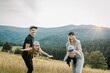 © Serhii - Parents hold in hands and throw up happy children into the sky. Mother, father, son and daughter walking on an autumn day. Mom, dad and kids in the mountains. Family spending time. World Tourism Day.