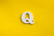 letter Q uppercase - white wood letter on yellow color background