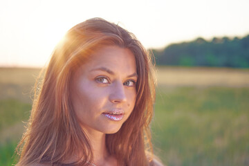 Wall Mural - Portrait of a beautiful smiling young girl at sunset