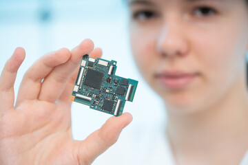 Wall Mural - young female laboratory assistant holding a prototype circuit board for a solar energy system control device