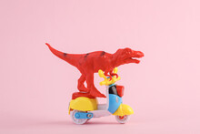 Toy Red Dinosaur Tyrannosaurus Rex Ride On Scooter, Pink Background. Minimalism Creative Layout.