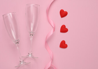 Wall Mural - Two Glasses with red hearts and ribbon on pink background. Love, romantic concept, valentine's day, Flat lay