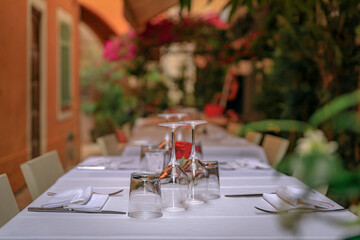 Wall Mural - A table at an outdoor restaurant with traditional old terracotta houses in old town or Vieille Ville in Villefranche sur Mer, South of France